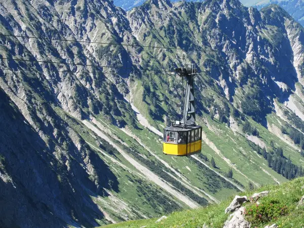 Gelbe Seilbahn schwebt über steile Hänge, ideal für eine Nebelhorn Wanderung.